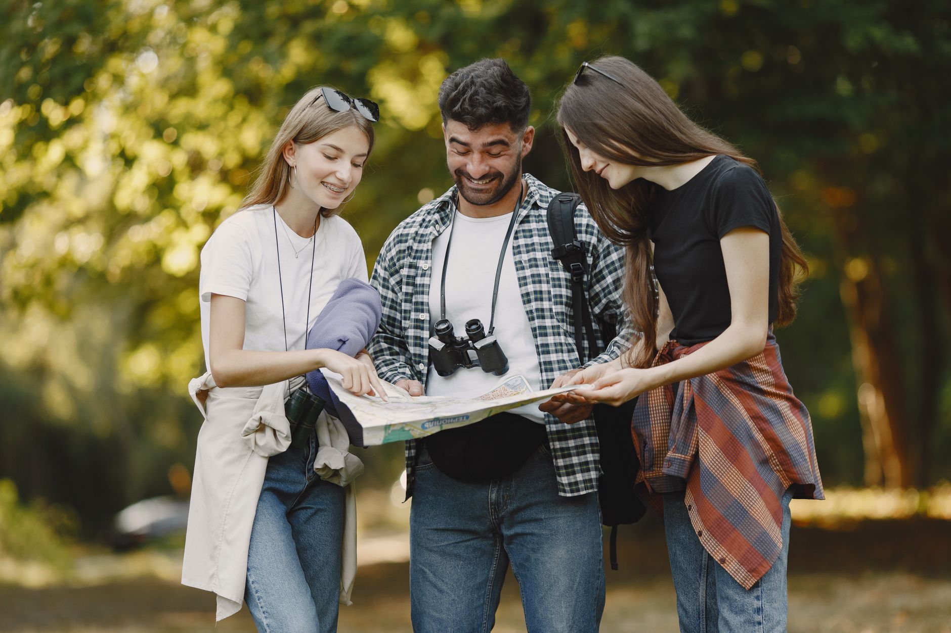 A group of friends joyfully navigates the outdoors with a map, embodying adventure and exploration. — Jumeirah Residences Emi