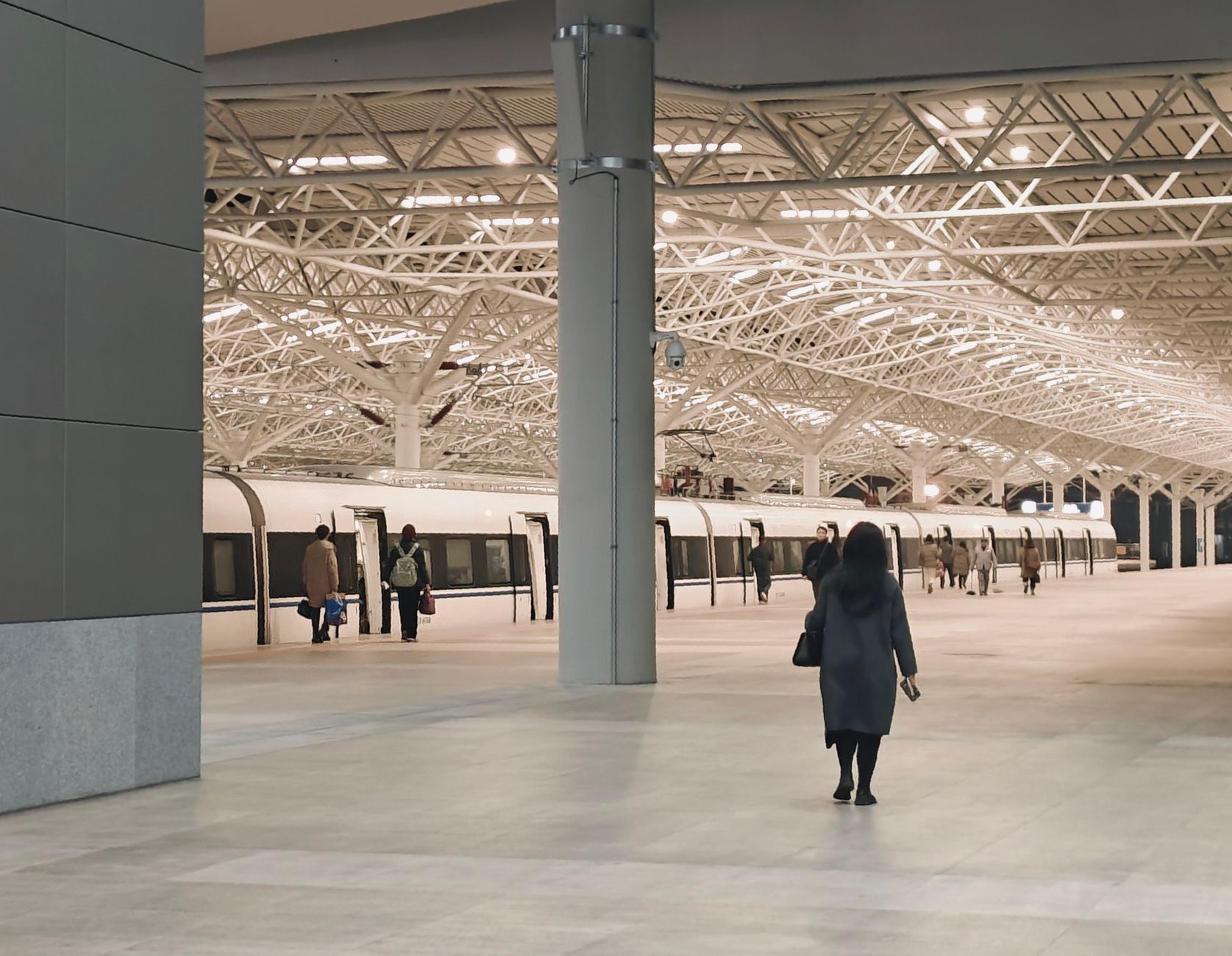 A modern train station interior with passengers walking towards a waiting train. — Visa-Exempt Travelers to Korea: Ensure Ent
