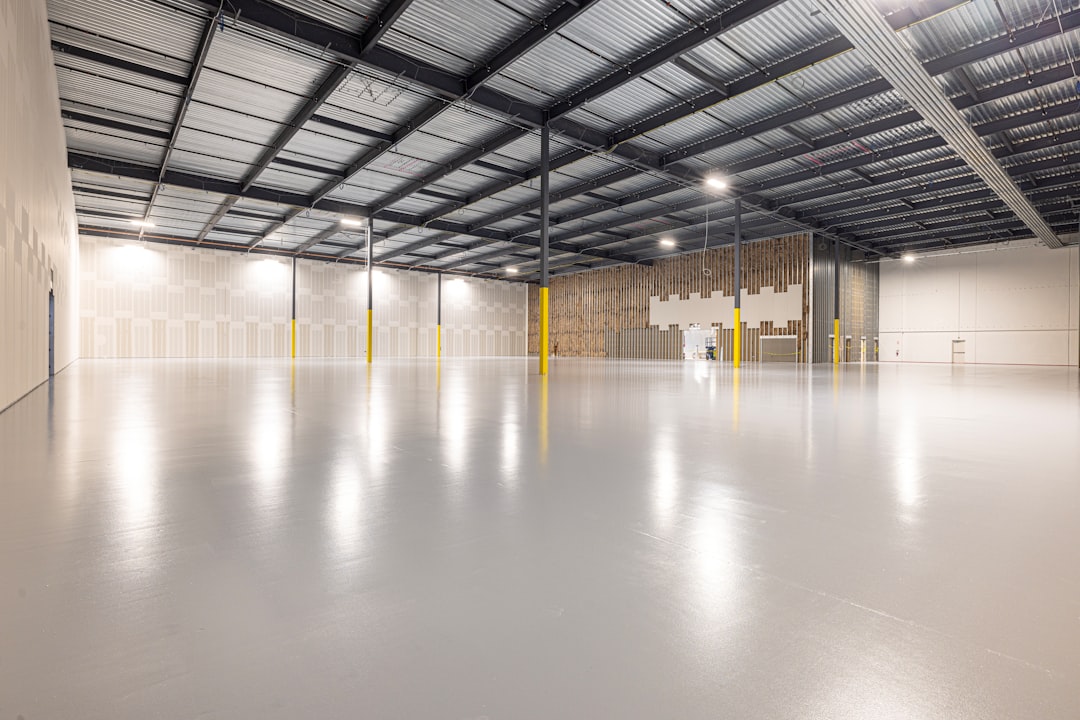 Large empty commercial space with an epoxy floor and high ceiling