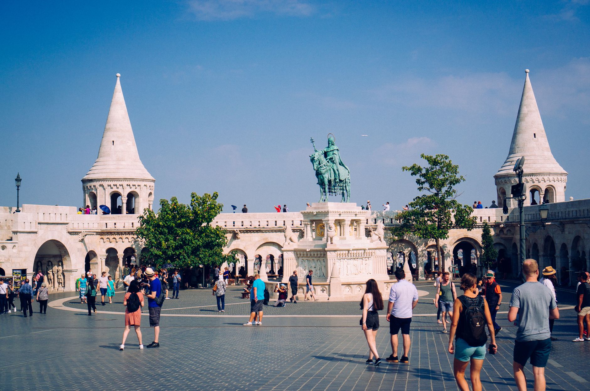Tourists exploring Fisherman's Bastion and Saint Stephen statue in vibrant Budapest. — Why You Should Trust a Professional Se